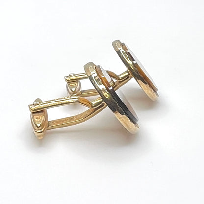 Side view of vintage tiger eye cufflinks with gold tone toggle backs