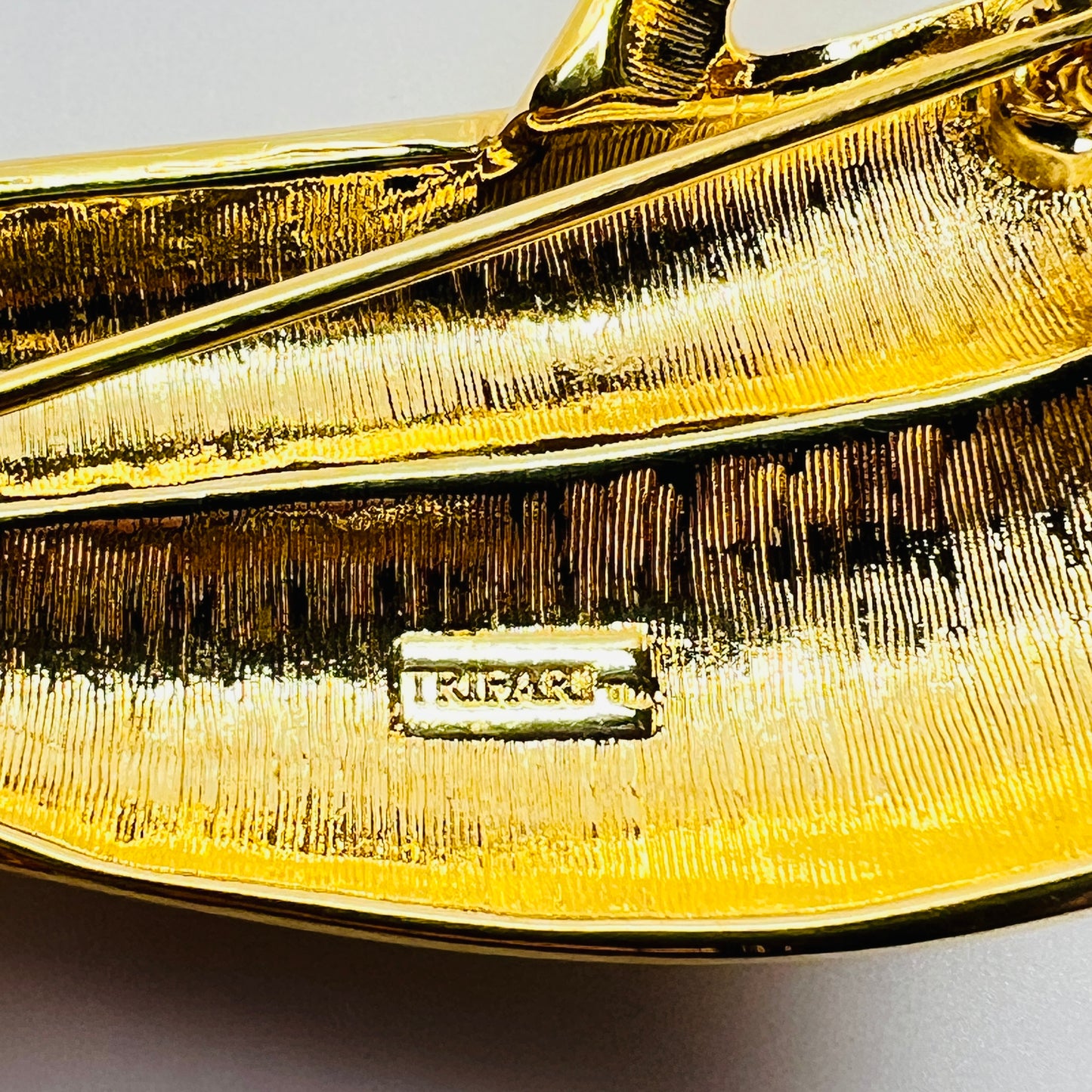 Signed Trifari TM mark on reverse of vintage gold tone brooch