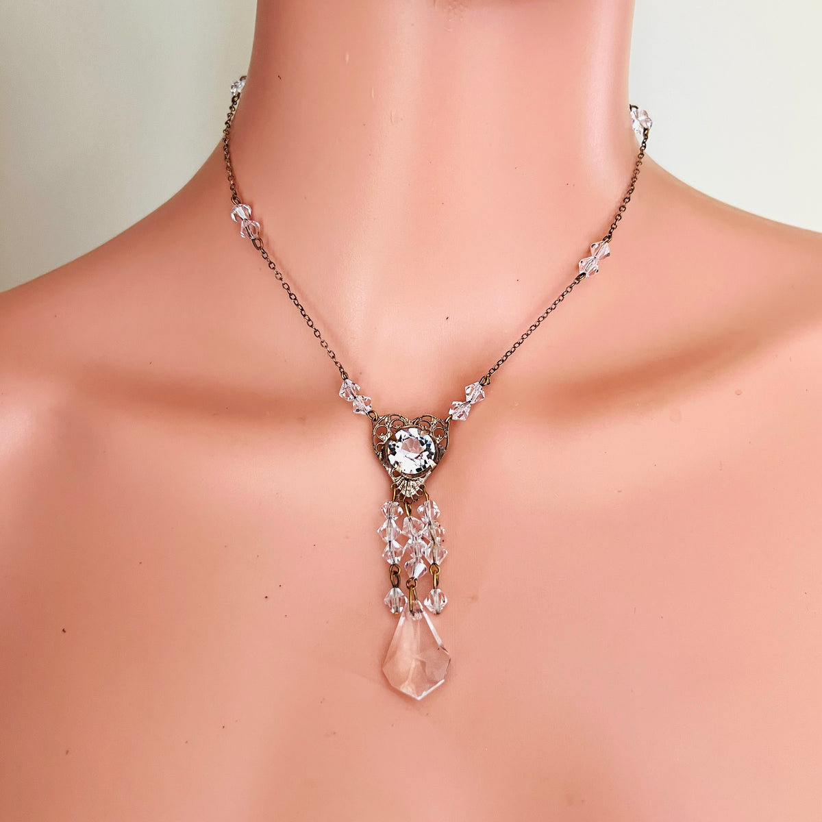 Antique crystal filigree tassel necklace displayed at the neckline