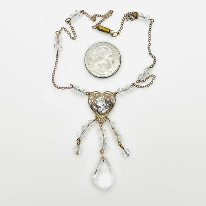 Vintage 1920s crystal necklace with heart filigree pendant shown beside quarter for scale