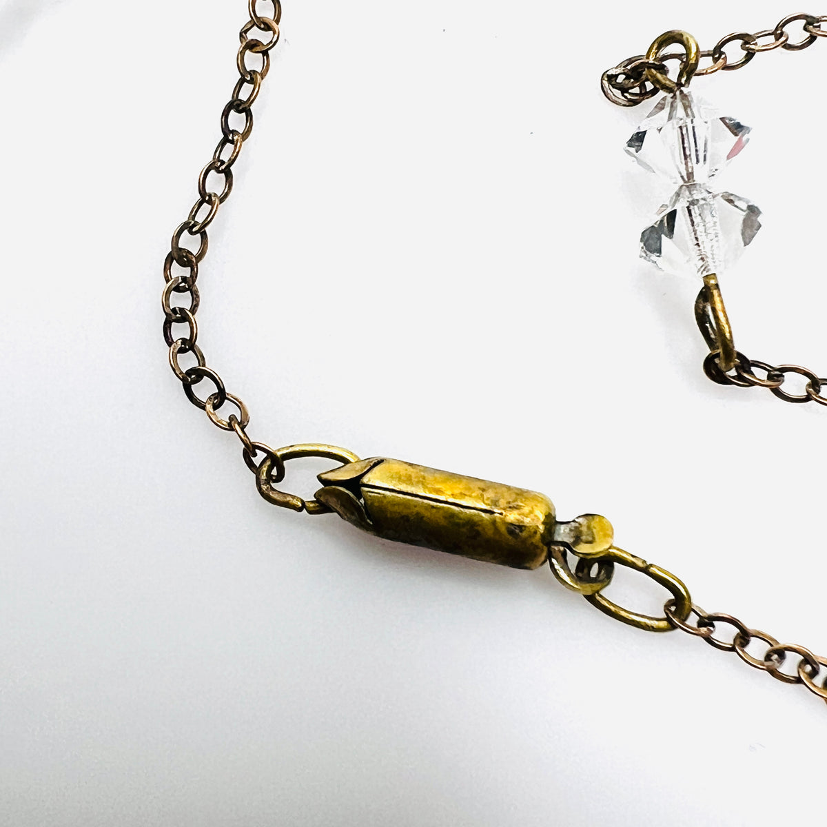 Close-up of vintage barrel clasp and aged metal chain on 1920s crystal necklace