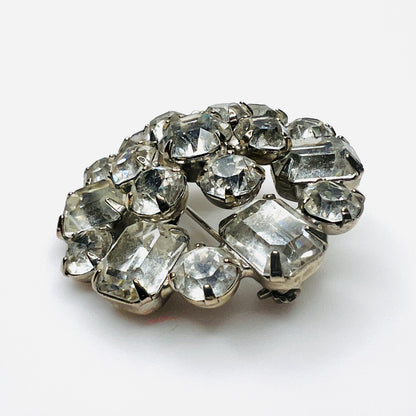 Side view of vintage Weiss rhinestone brooch showing raised silver-tone settings and dimensional crystal cluster construction.