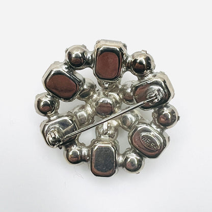 Reverse of vintage 1950s Weiss clear rhinestone brooch showing silver-tone backing, openwork construction, and rollover clasp.