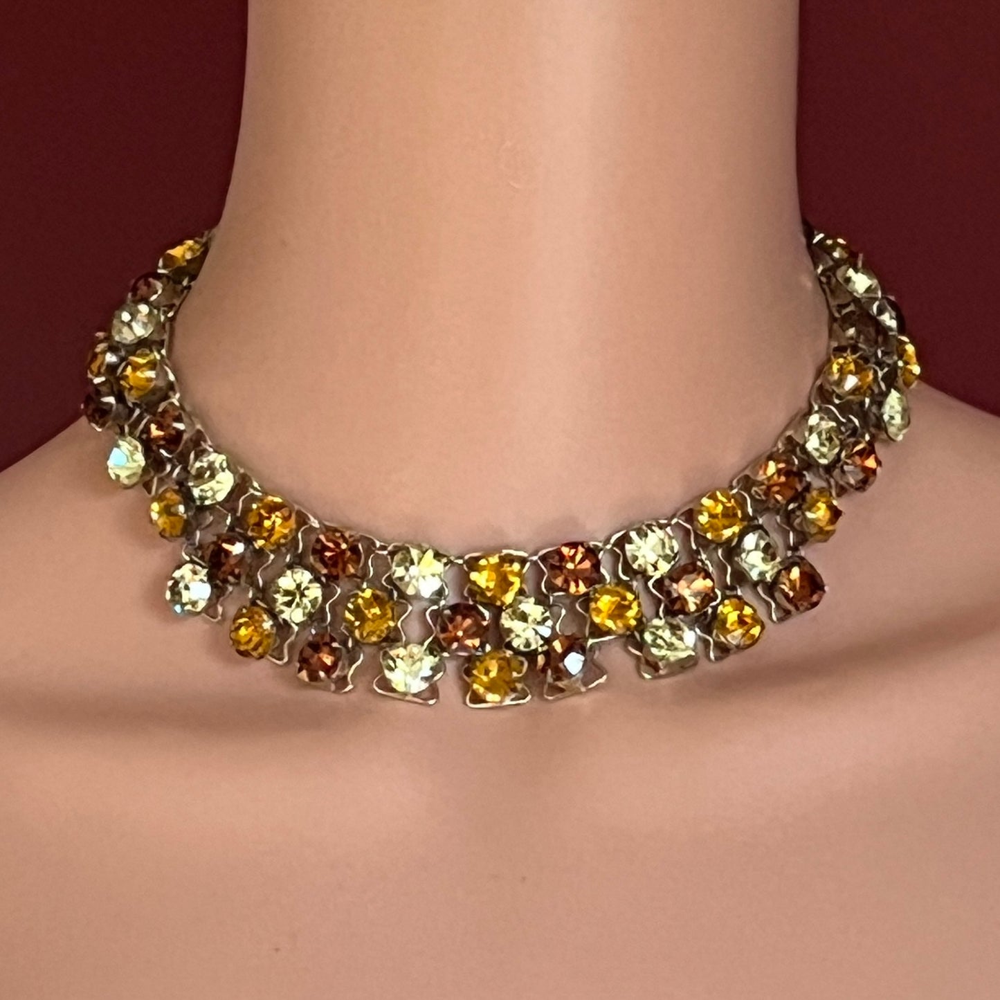 Close-up of graduated rhinestone collar necklace in gold and citrine hues