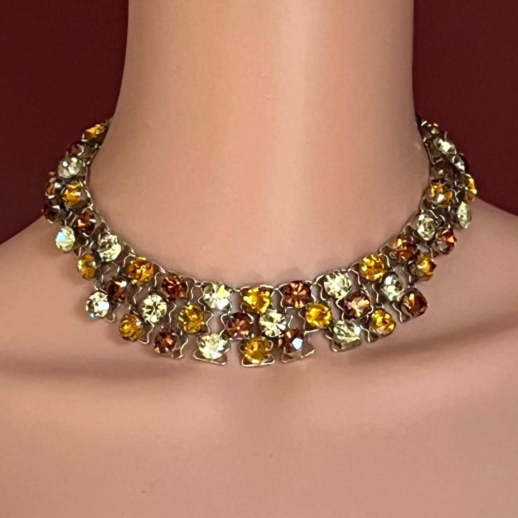 Close-up of graduated rhinestone collar necklace in gold and citrine hues
