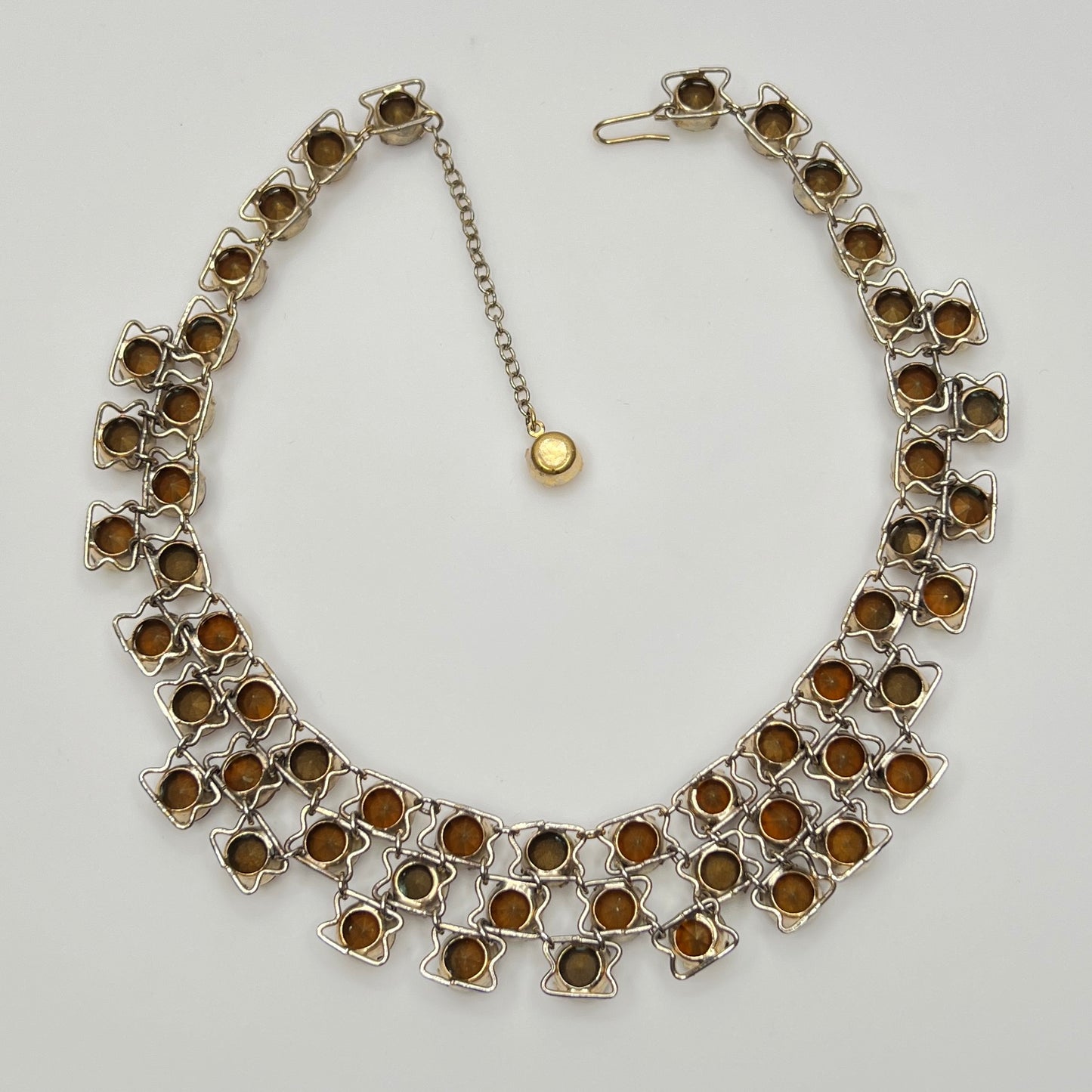 Close-up of graduated rhinestone collar necklace in gold and citrine hues