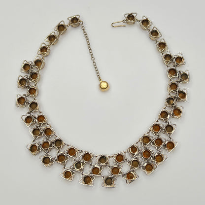 Close-up of graduated rhinestone collar necklace in gold and citrine hues