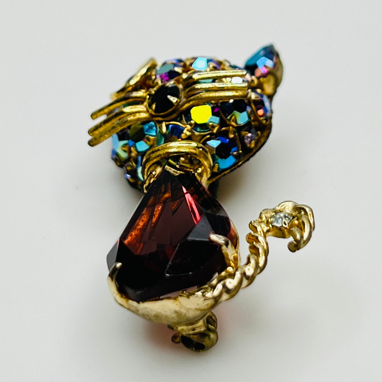 Angled view of vintage cat brooch showing gold tone finish and rhinestone details