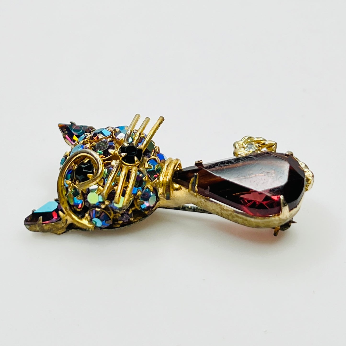 Angled view of vintage cat brooch showing gold tone finish and rhinestone details