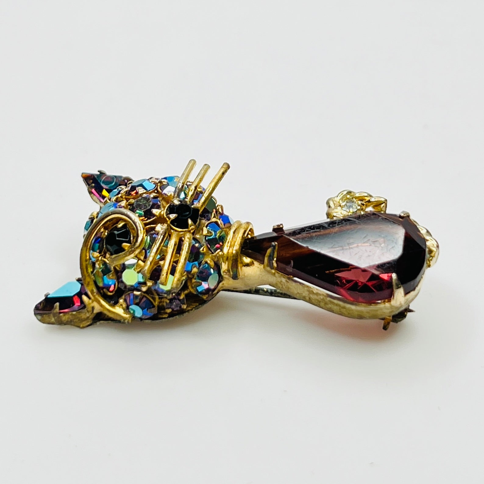 Angled view of vintage cat brooch showing gold tone finish and rhinestone details