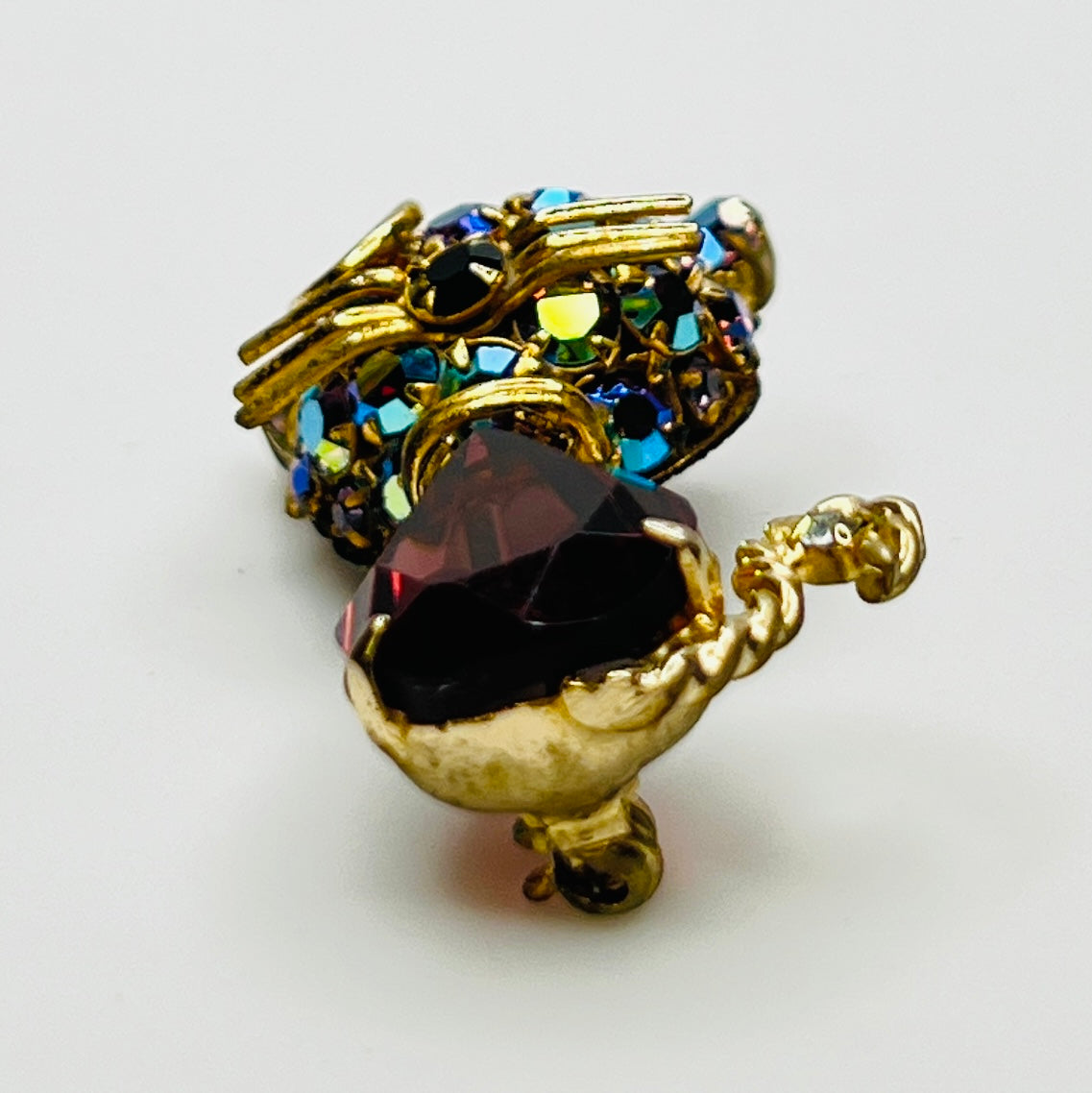 Angled view of vintage cat brooch showing gold tone finish and rhinestone details