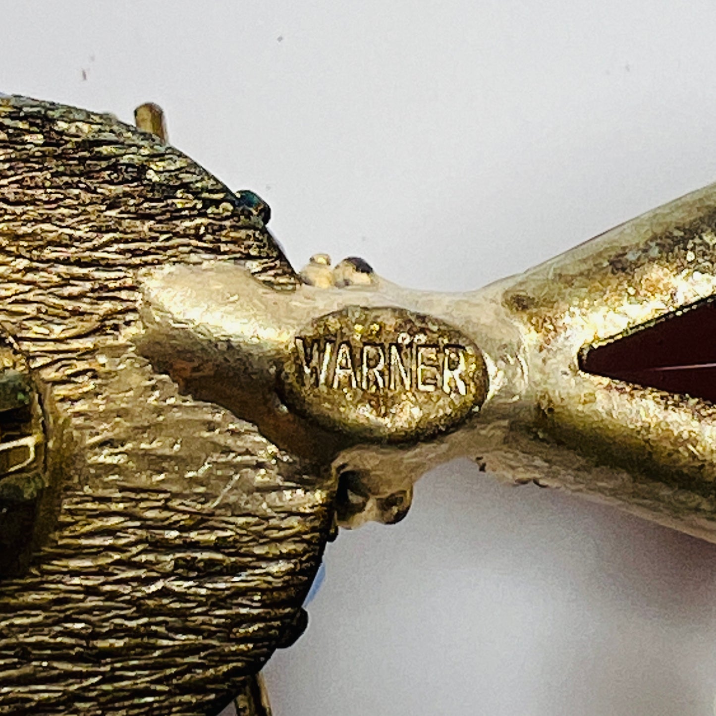 Close-up of WARNER maker’s mark on back of vintage brooch