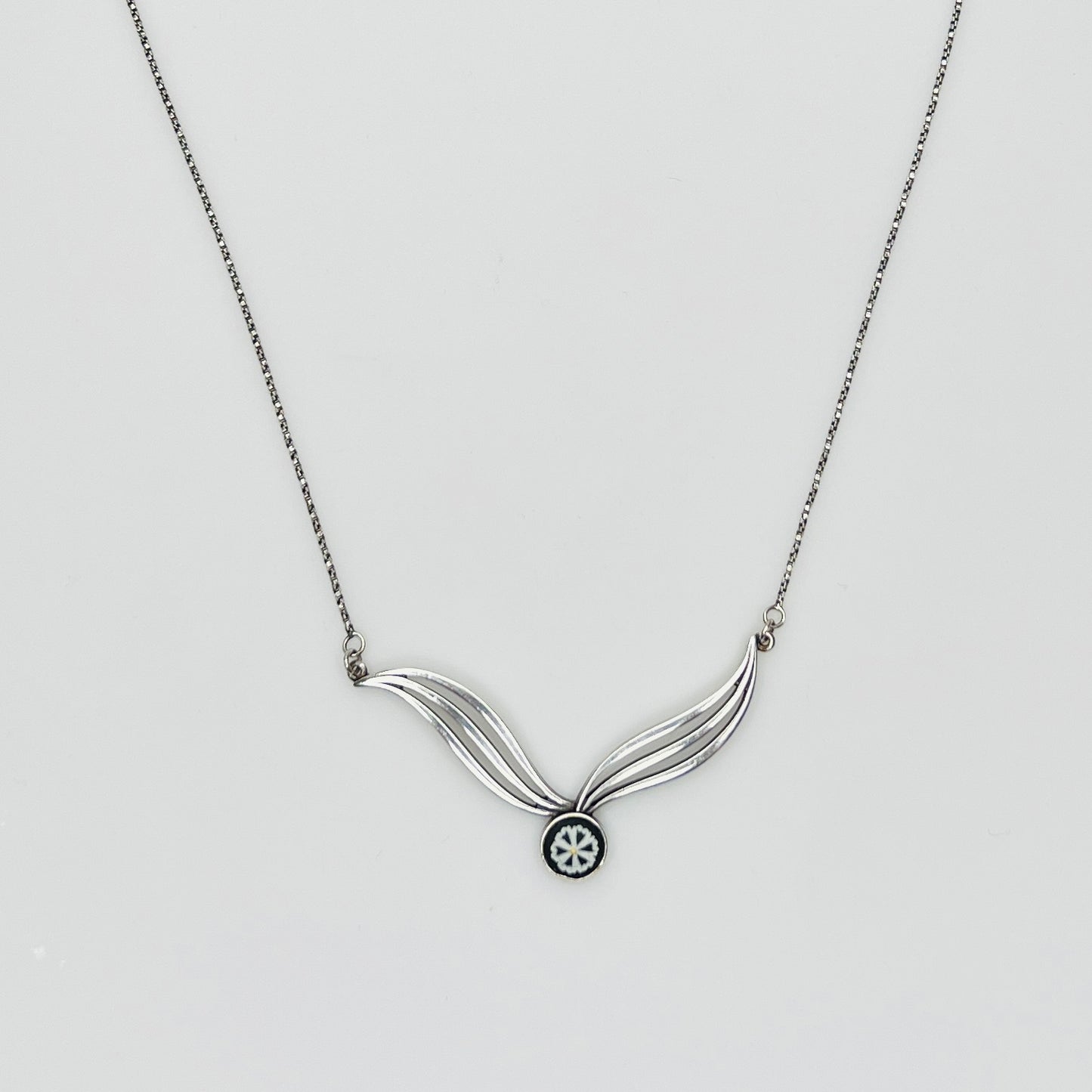 Flat lay of silver Wedgwood pendant necklace with chain