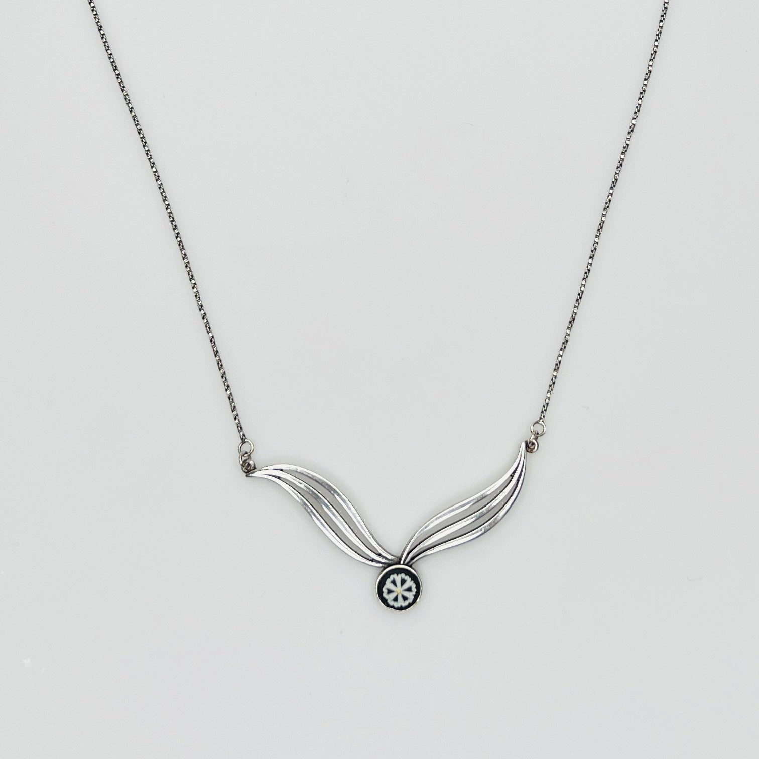 Flat lay of silver Wedgwood pendant necklace with chain