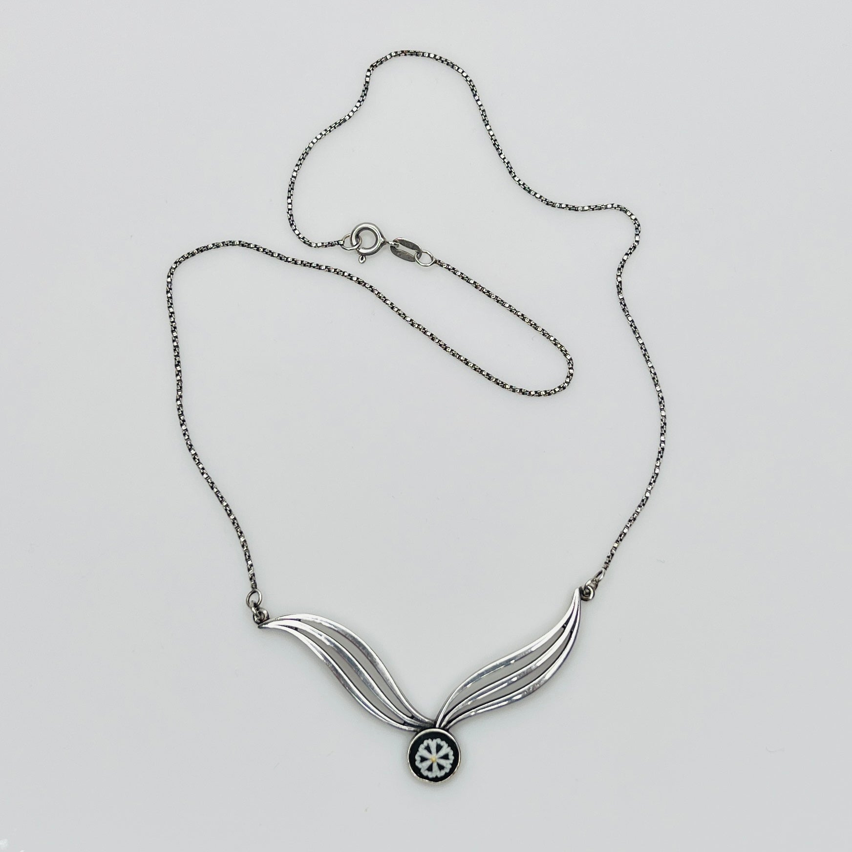 Flat lay of silver Wedgwood pendant necklace with chain