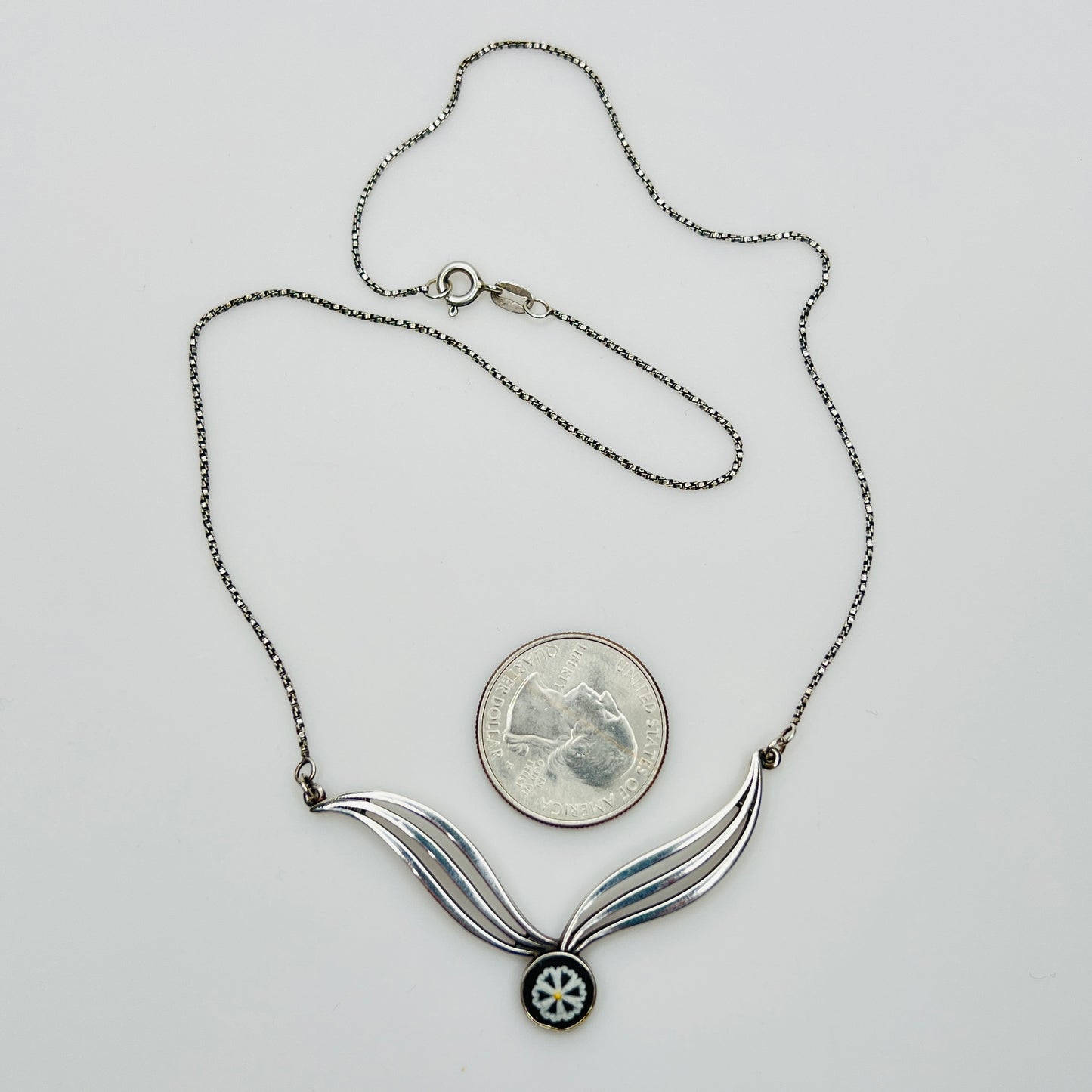 Flat lay of silver Wedgwood pendant necklace with chain