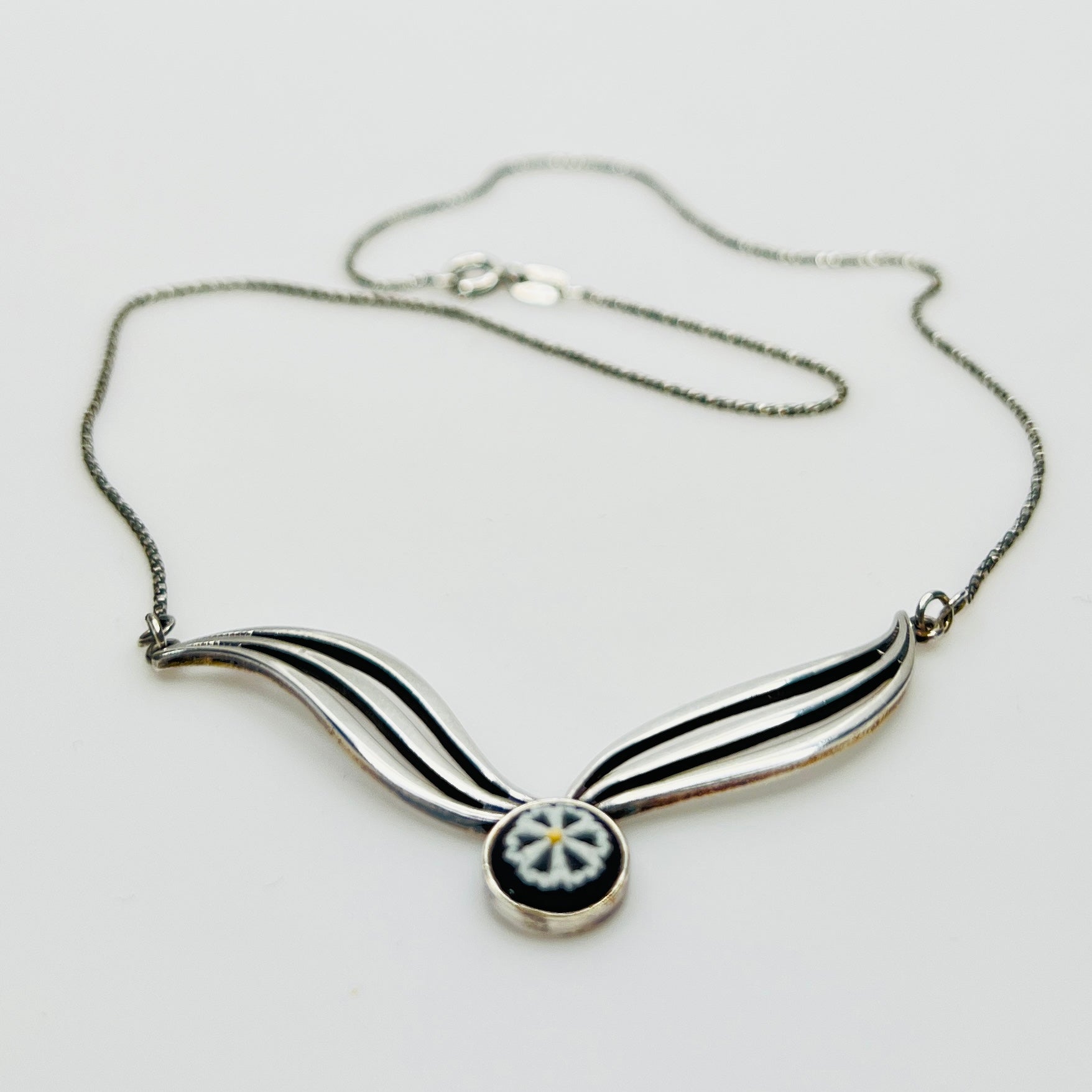 Flat lay of silver Wedgwood pendant necklace with chain