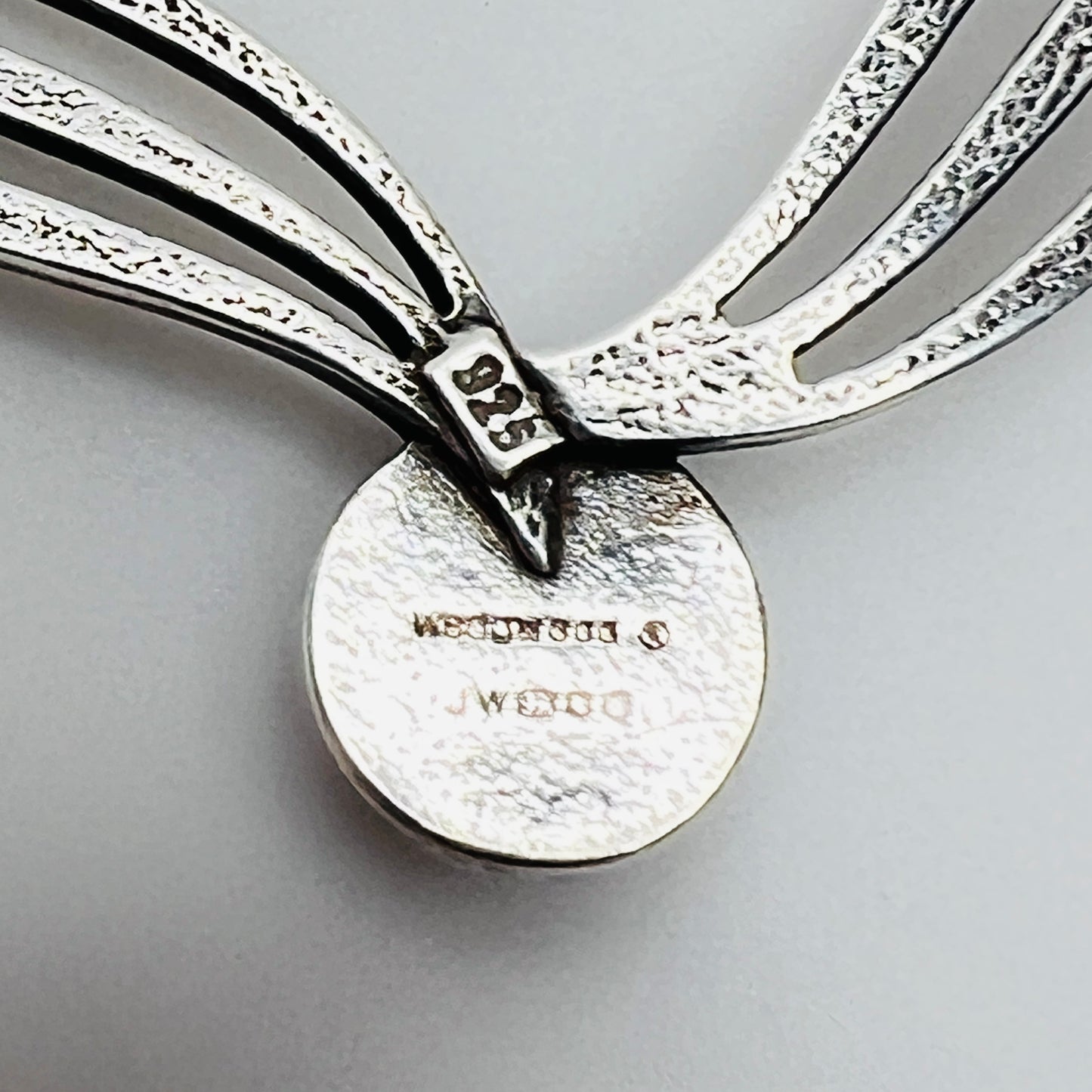 Close-up of sterling stamp and Wedgwood maker’s mark on back