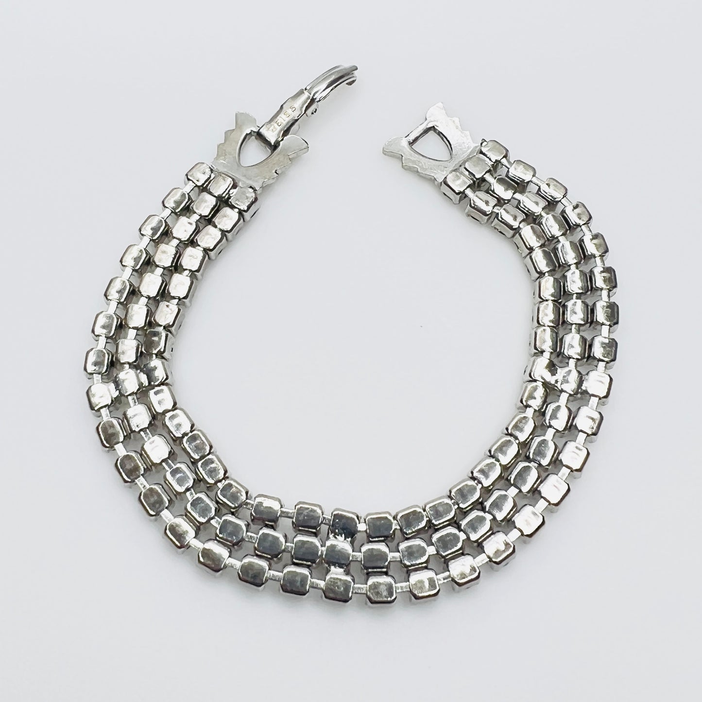 Back View Signed Weiss triple strand clear crystal rhinestone bracelet in silver tone metal