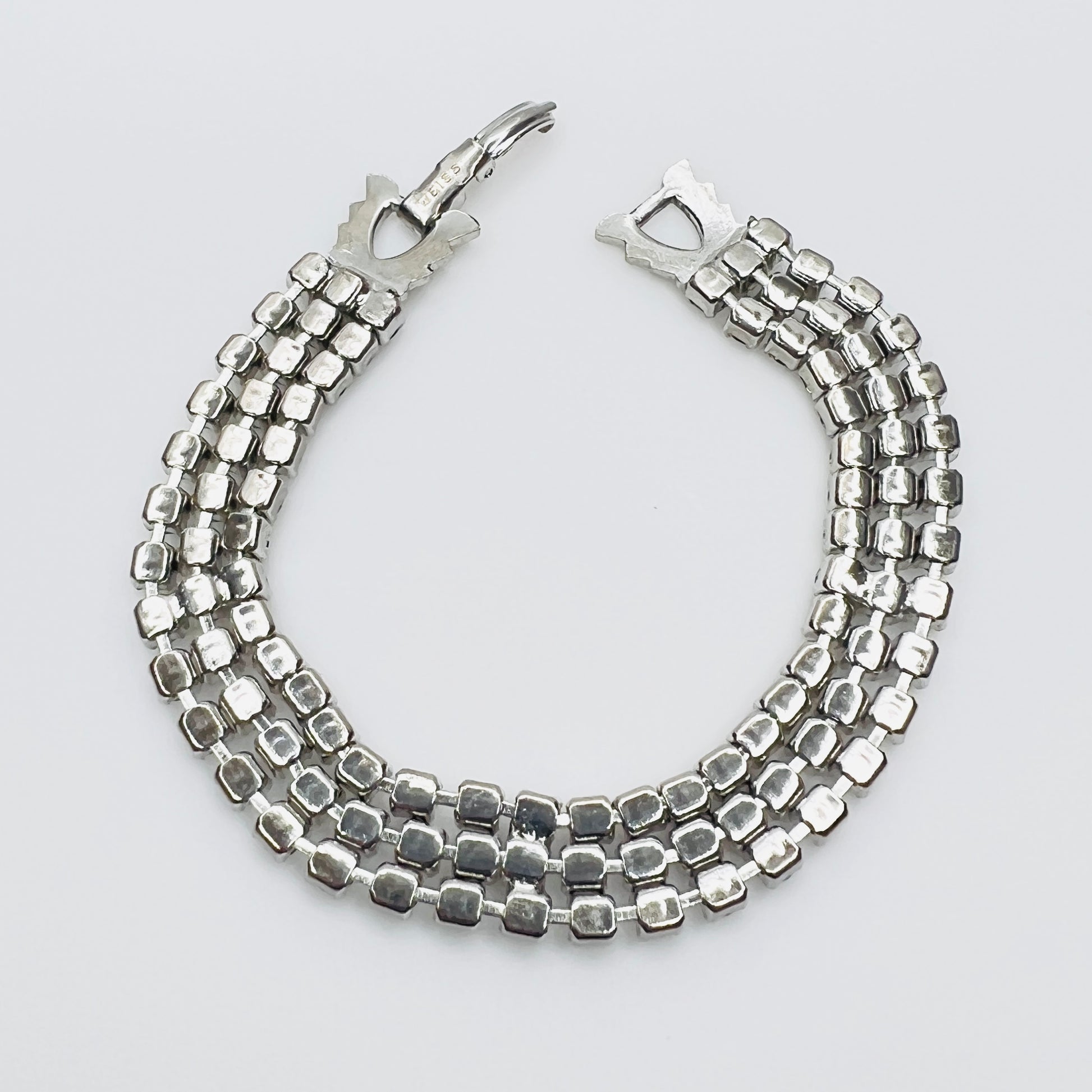 Back View Signed Weiss triple strand clear crystal rhinestone bracelet in silver tone metal