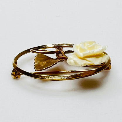 Side view of circular rose pin with gold-tone leaves
